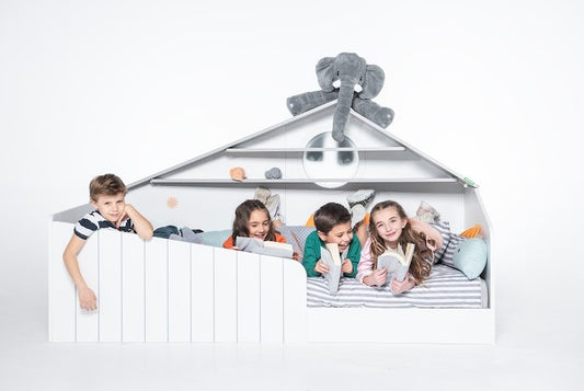 Bird House Montessori Bett für Kinder – Weißes Häuschen-Bett mit Spielbereich, Bücherregal und fröhlich spielenden Kindern